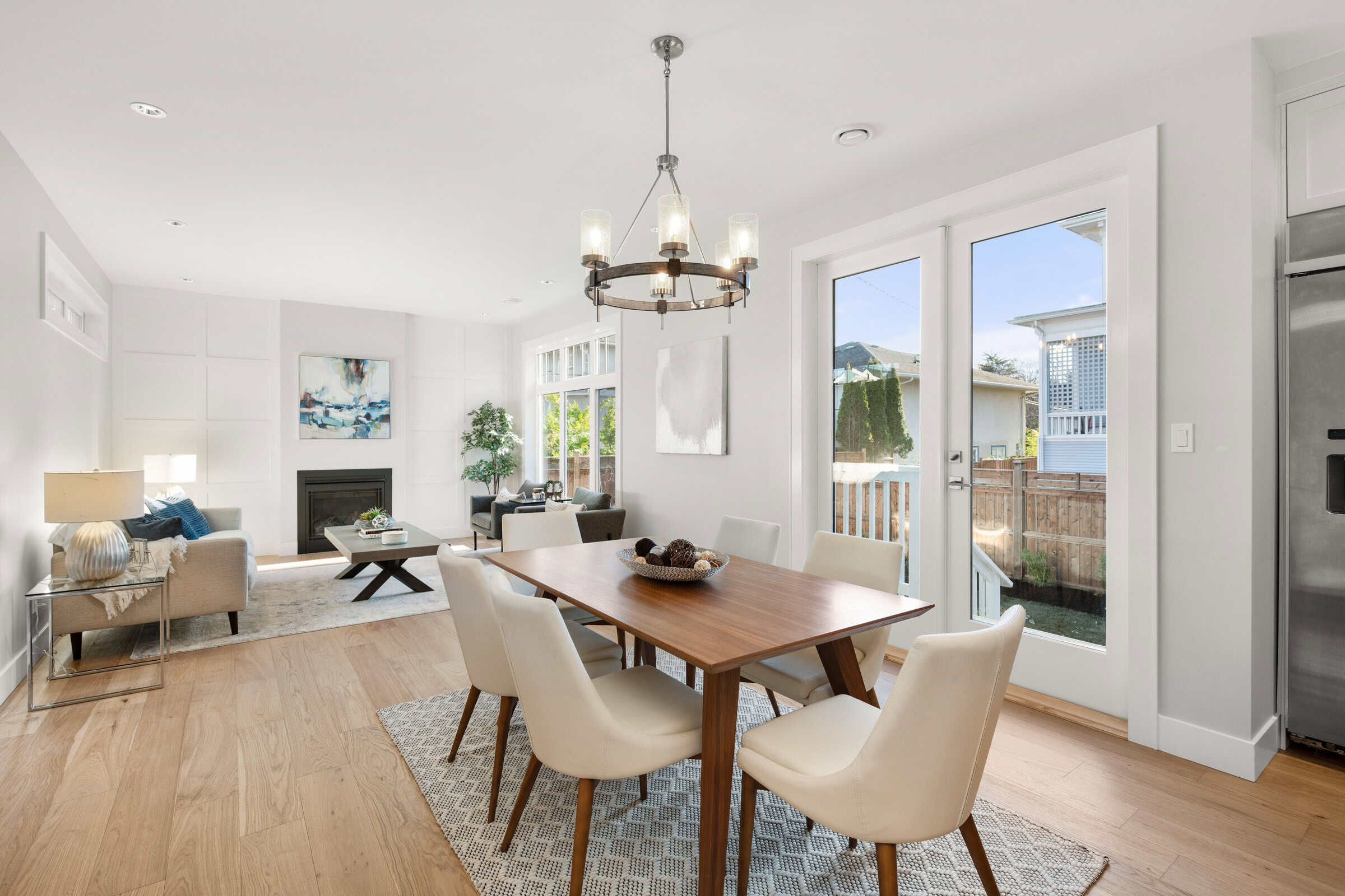 Bright dining room with wooden table, beige chairs, and natural light from large windows.