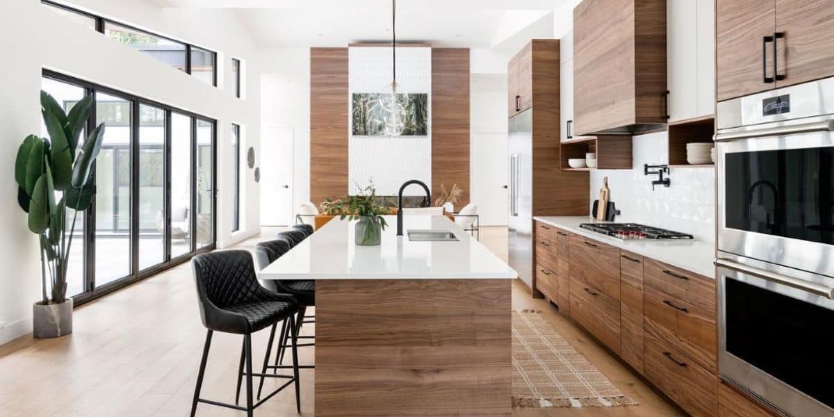 Modern kitchen with wooden cabinets and large island in a bright open-plan space.