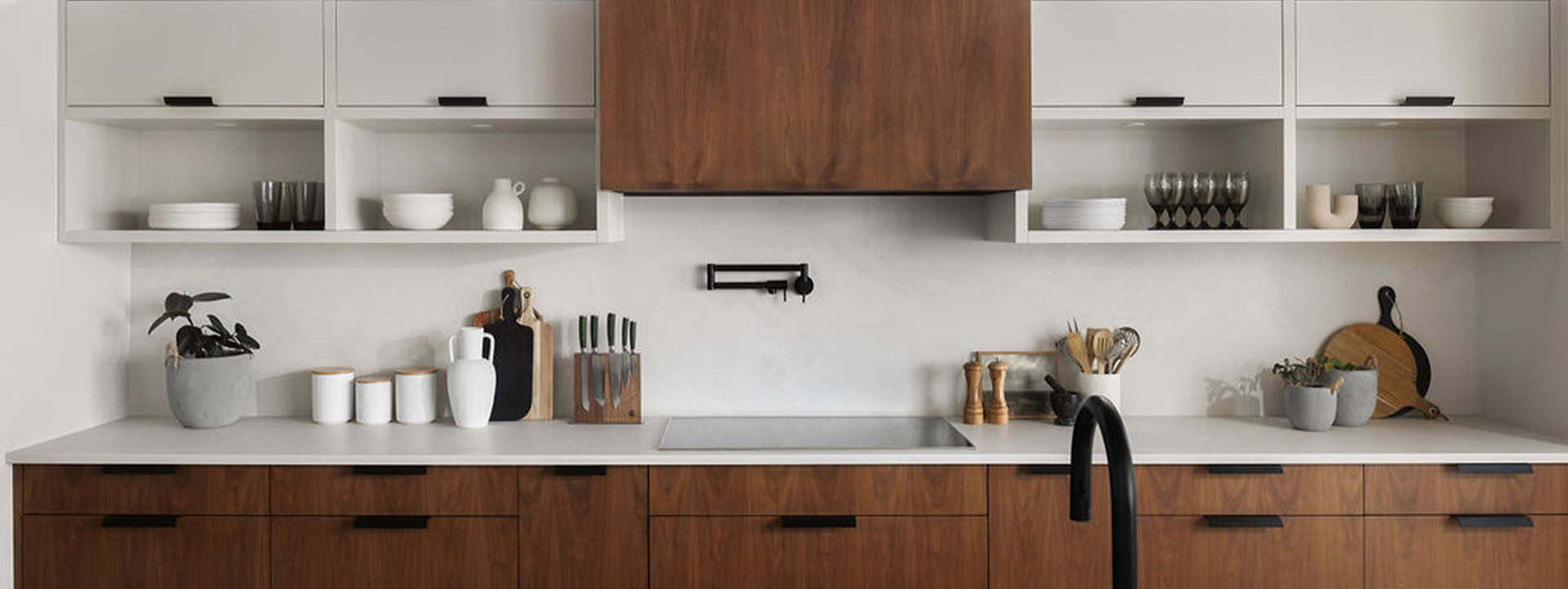 Modern kitchen with white cabinets and wood accents by White Wolf Homes.