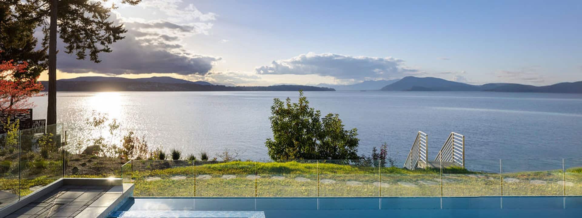 Victoria BC custom home builder waterfront view of Shawnigan Lake with calm water and distant hills.