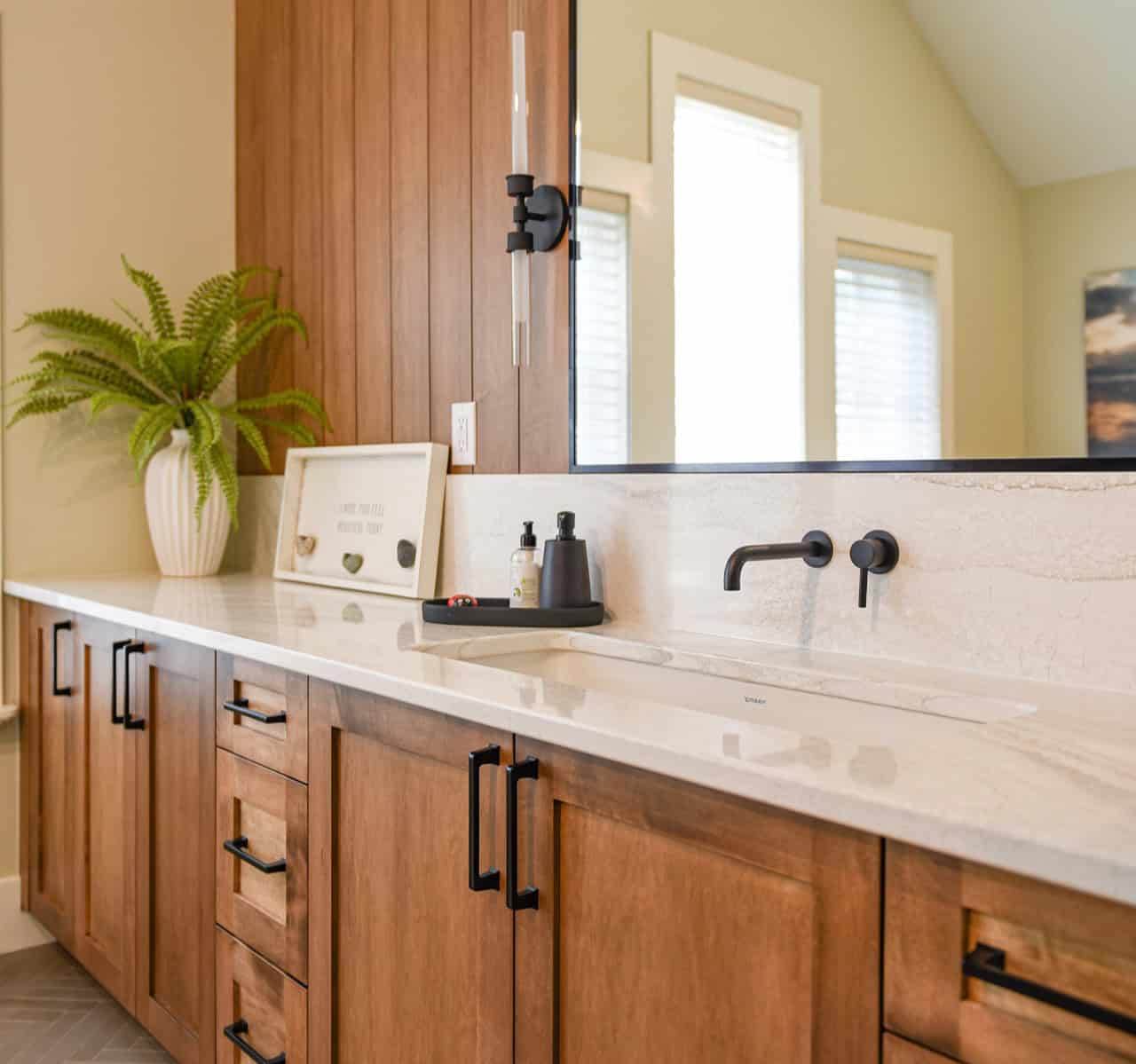 Modern bathroom vanity with wooden cabinets, marble countertop, and matte black fixtures in Victoria.