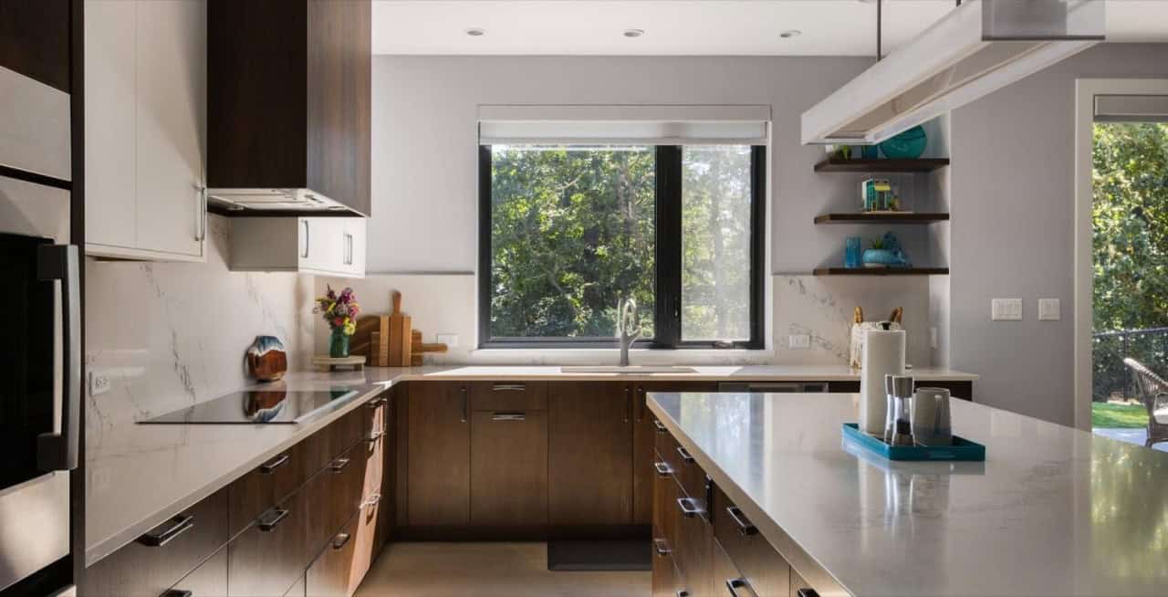 Bright, contemporary kitchen with large central island and window view in Victoria BC.