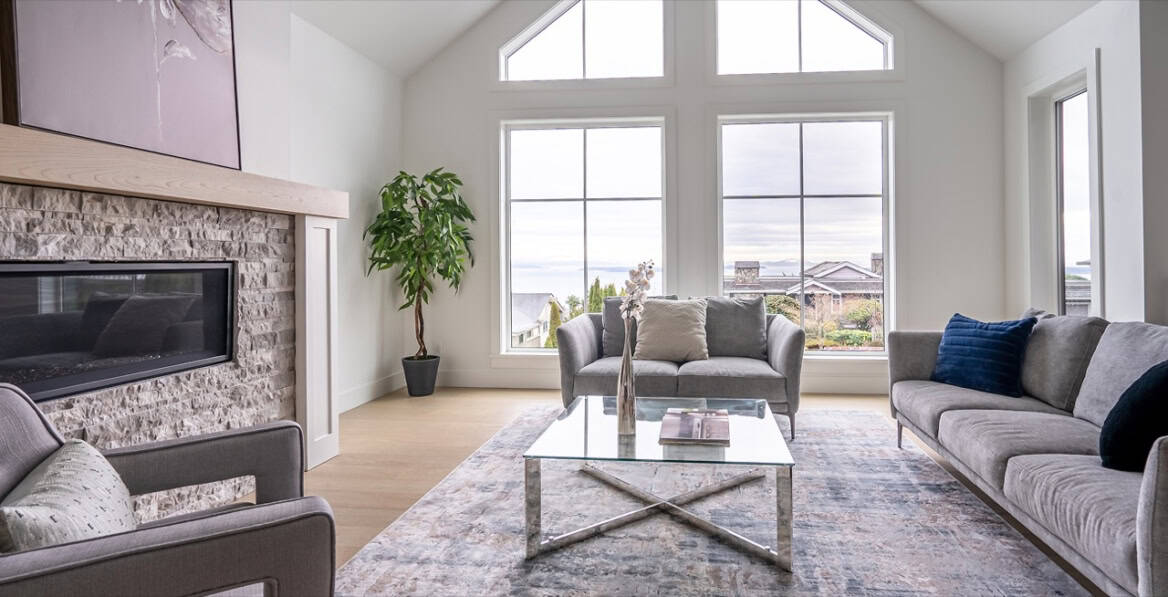 Bright living room with large windows, modern furniture and a view of outdoors.