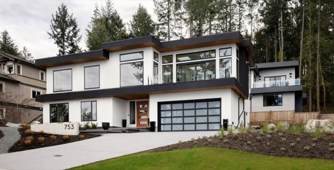 Modern custom home by White Wolf Homes in Victoria BC with large garage and glass facade.