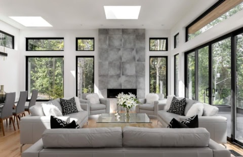 Bright modern living room with white furniture and large windows.