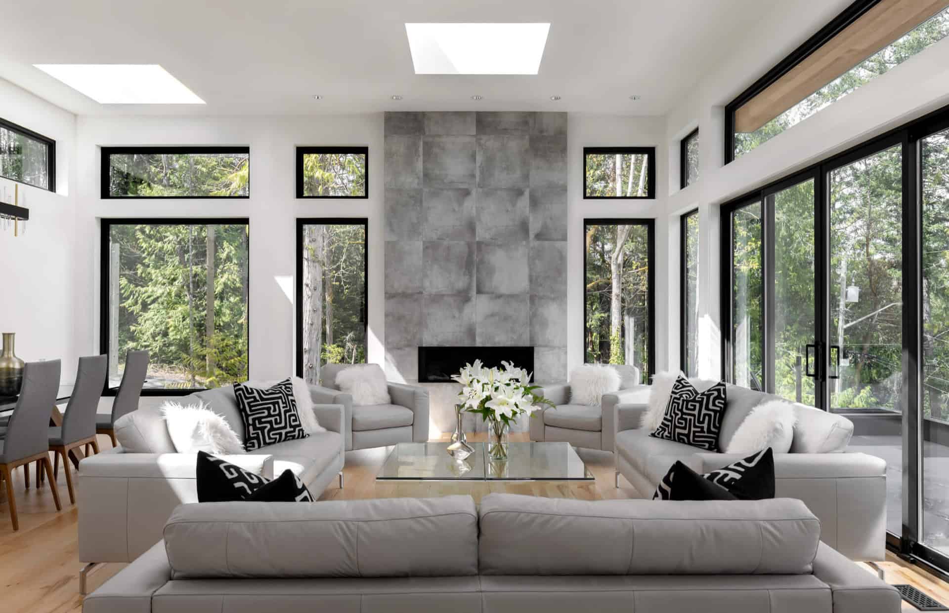 Bright modern living room with white furniture and large windows.