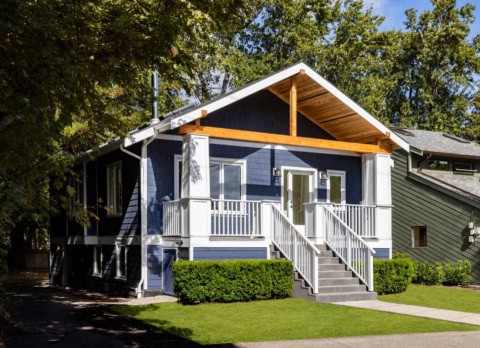 Blue modern home with white railing, front steps, and a covered porch in Victoria BC.