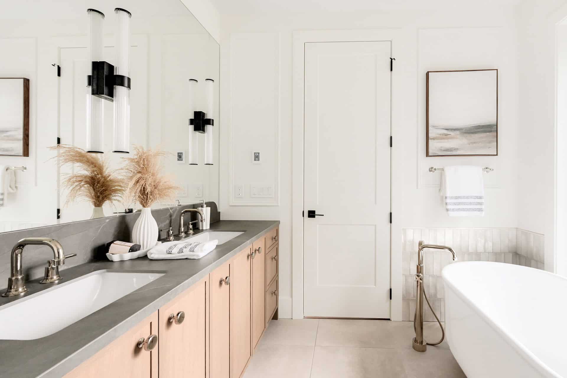 Bright, contemporary bathroom with dual sinks and freestanding tub in Westwyn project by White Wolf Homes.
