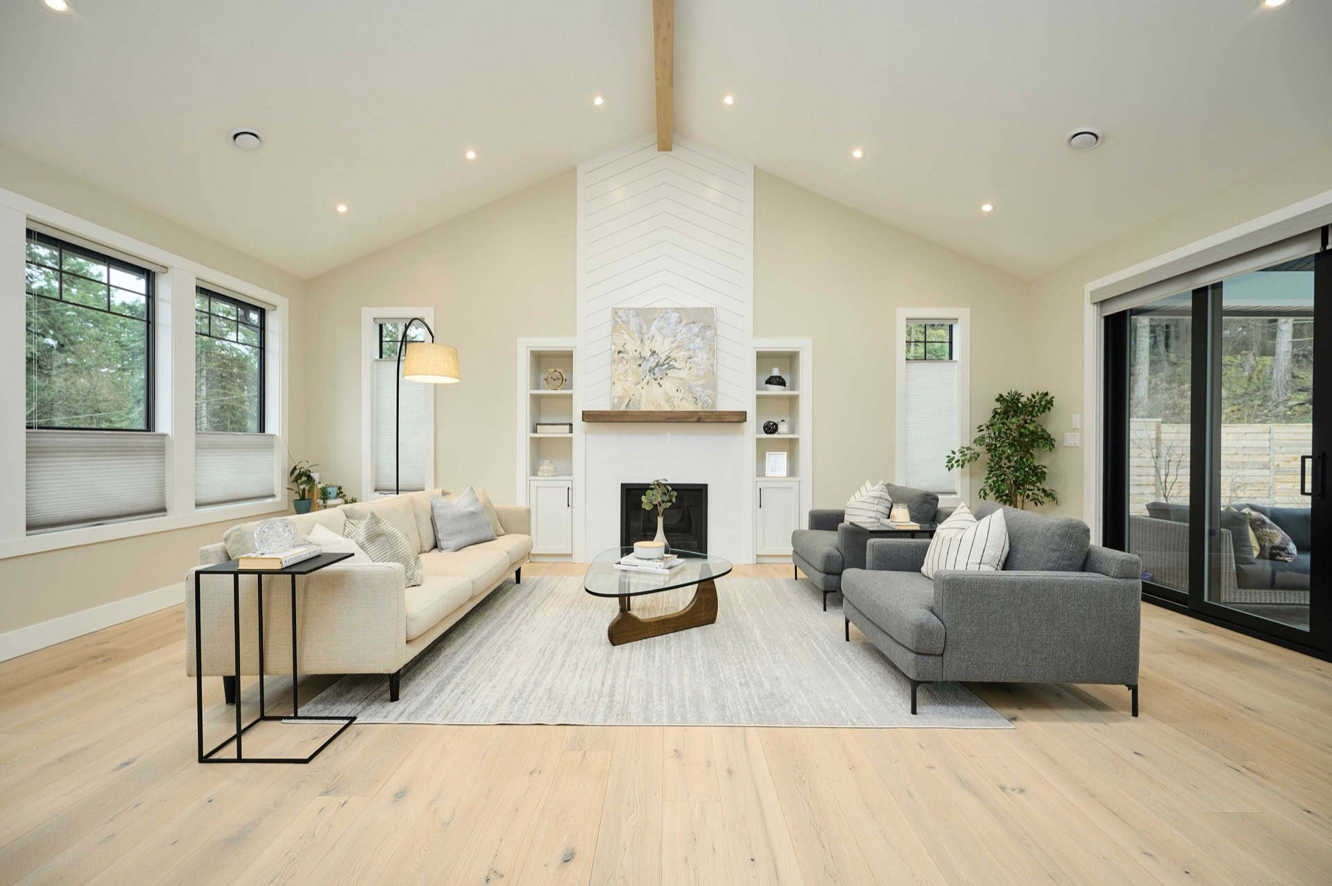 Bright living room with neutral furniture and fireplace centerpiece.