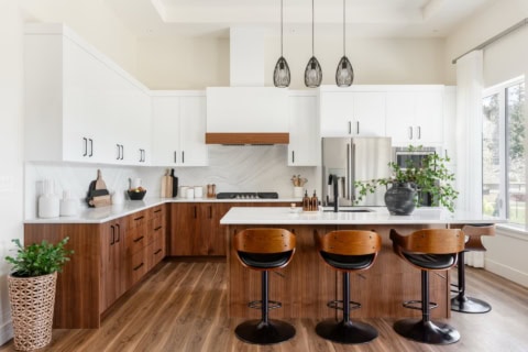 Modern white and wood kitchen with island, pendant lights and bar stools in Victoria BC.