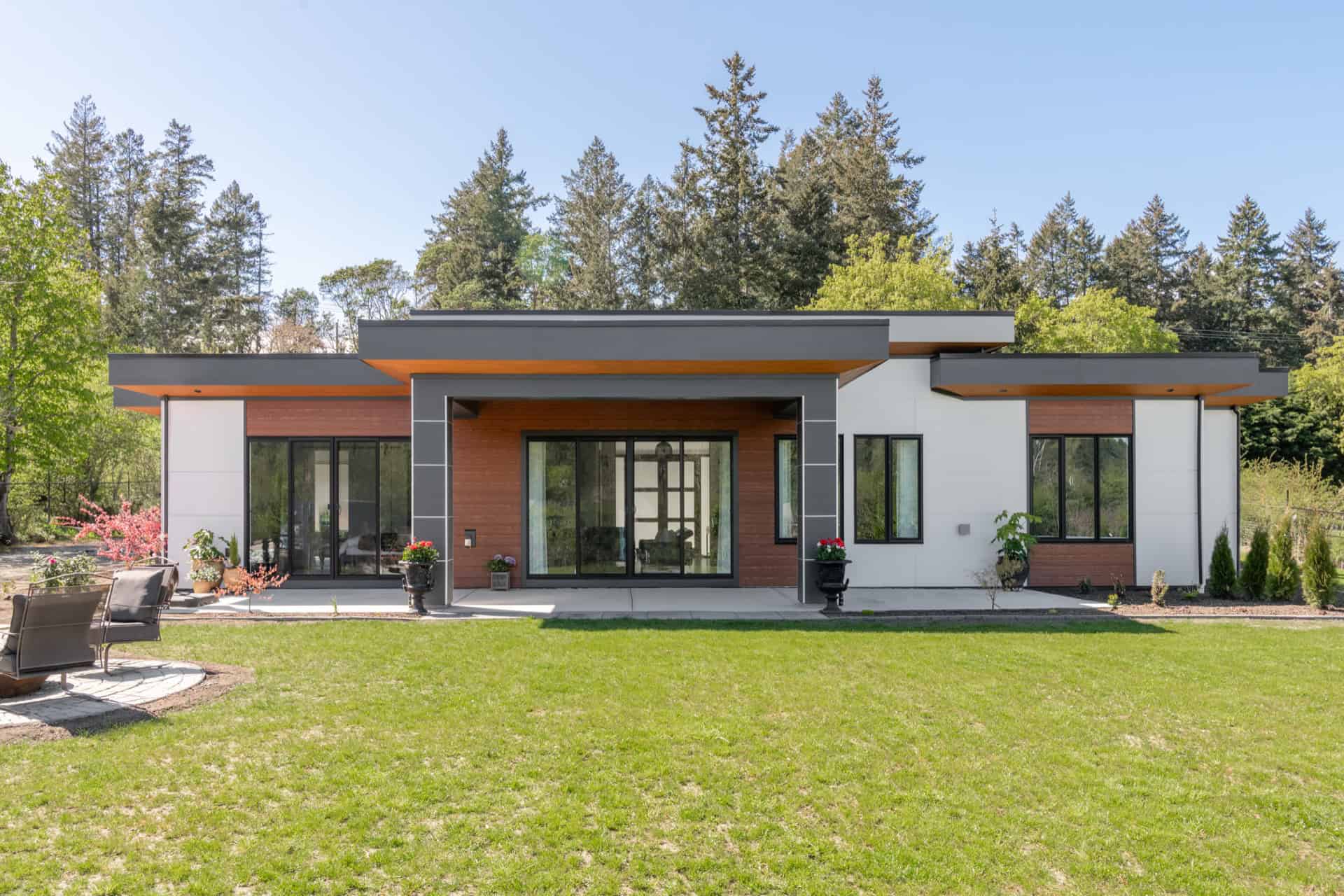 Modern single-story home by White Wolf Homes in Victoria BC with expansive lawn and patio.