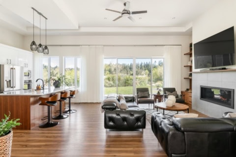 Spacious modern living room with large windows and fireplace.