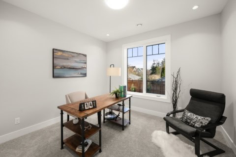Modern home office with desk, chair, and view of neighborhood through window.