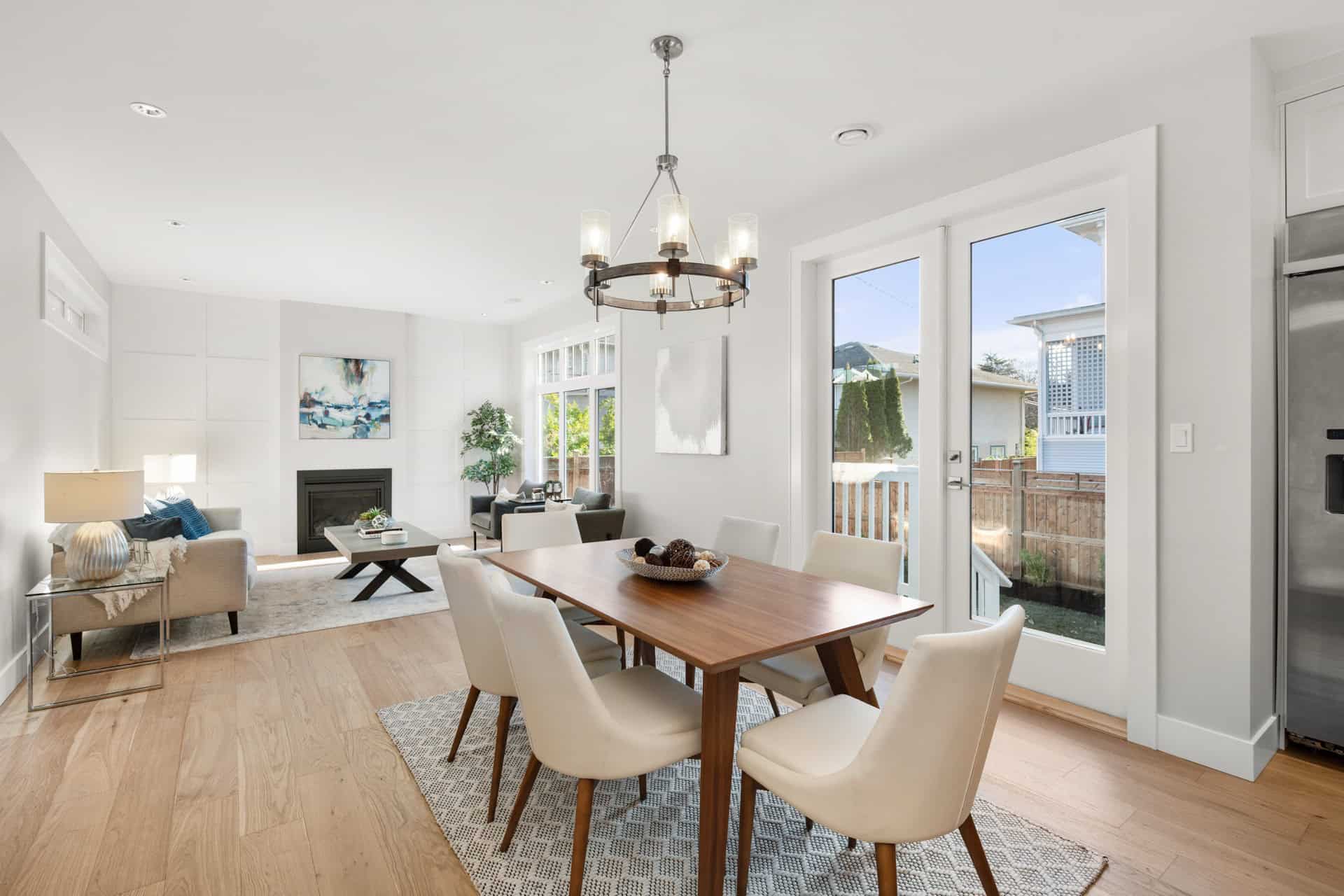 Bright open-concept living and dining area with a wooden table and modern chairs.