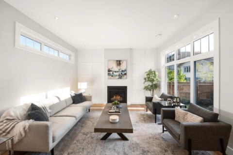 Bright modern living room with fireplace and large windows.
