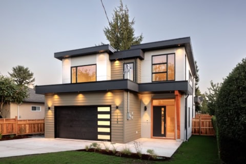 Modern two-story custom home in Victoria BC with illuminated entry and garage.