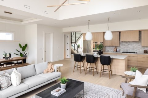 Bright open-concept living room and kitchen with modern white and wood finishes in a new Victoria BC home.