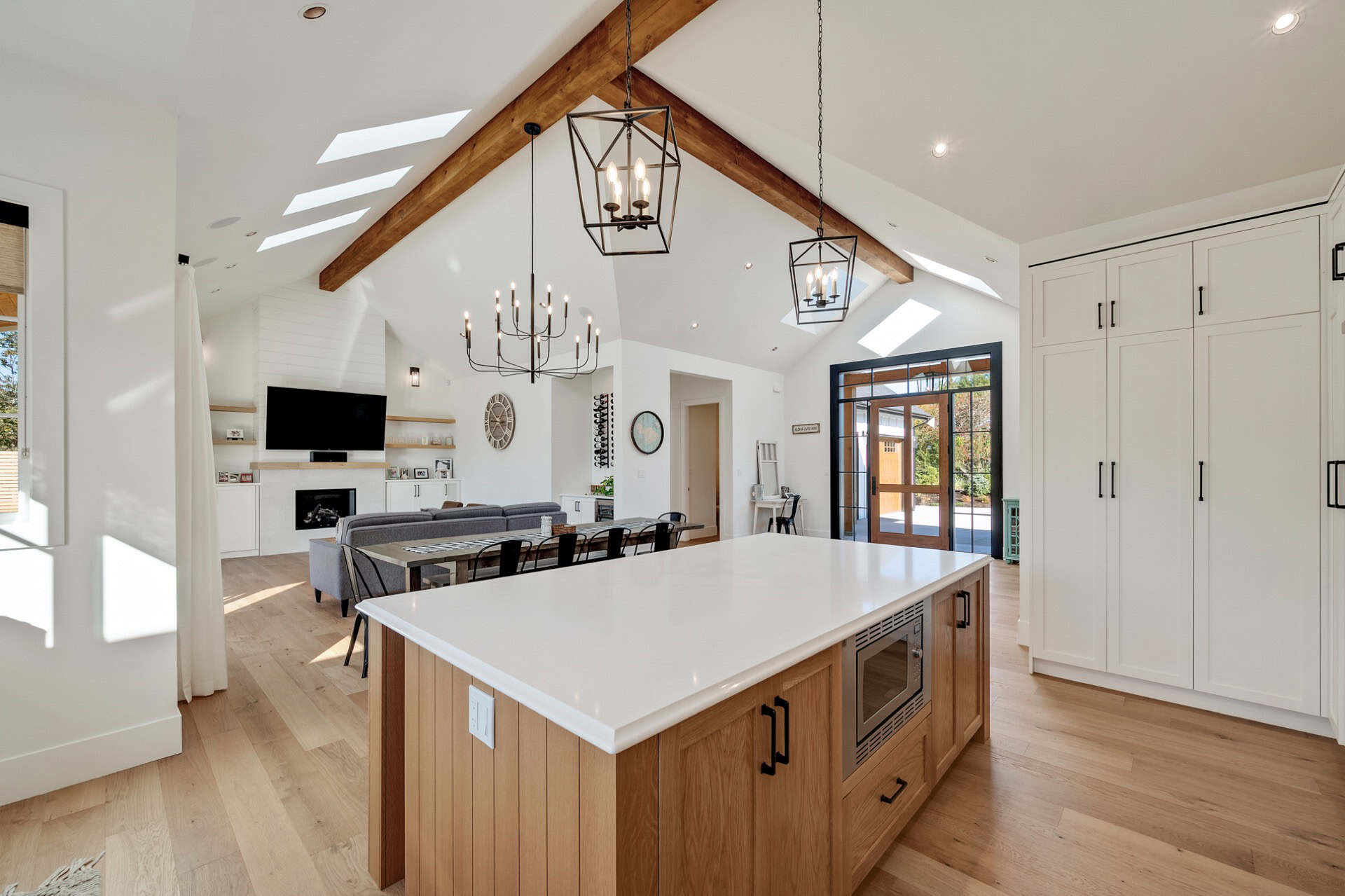 Open-concept kitchen with oversized island, vaulted ceiling, and modern lighting in a White Wolf Homes build.