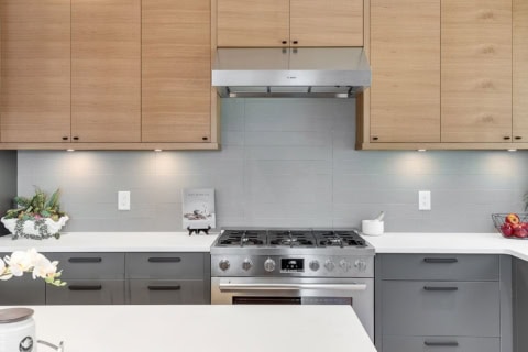 Modern kitchen by White Wolf Homes in Victoria BC with maple cabinets and stainless steel stove.