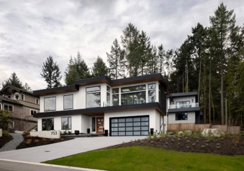 Modern two-story custom home by White Wolf Homes in Victoria BC with large glass windows.