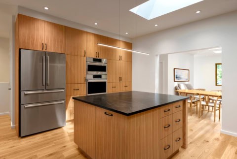 Modern kitchen with wooden cabinetry and island in Victoria BC home by White Wolf Homes.