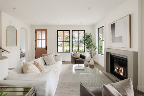 Modern living room with white sofa, fireplace, and large windows in a Victoria BC home.