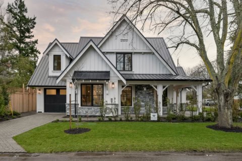 Custom Victoria BC home with white siding, gray roof, stone accents, front porch, and landscaped yard.
