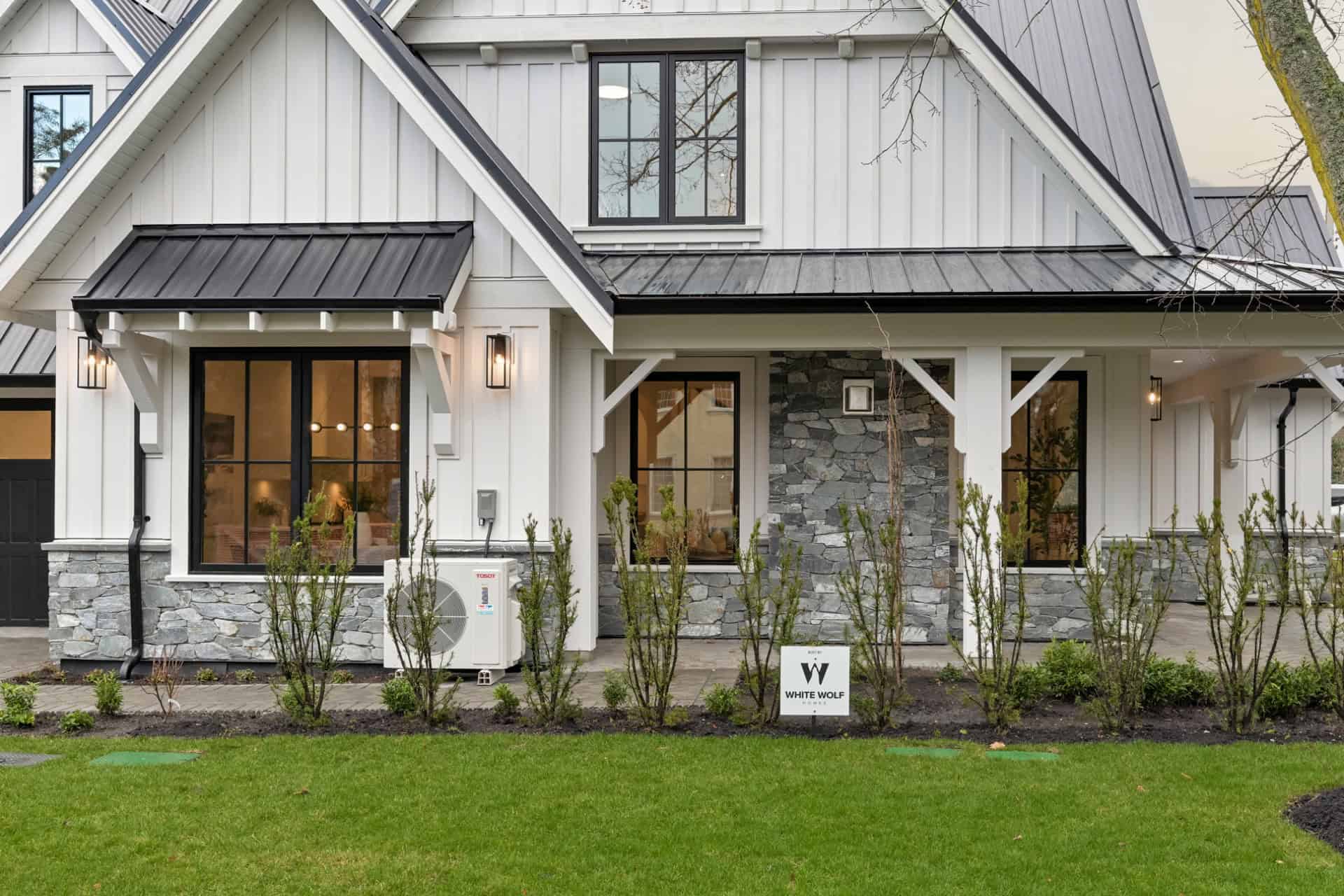 White Wolf Homes custom home facade in Victoria BC with stone accents and white siding.