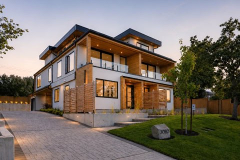 Modern custom home in Victoria BC by White Wolf Homes with brick, wood accents and large windows.