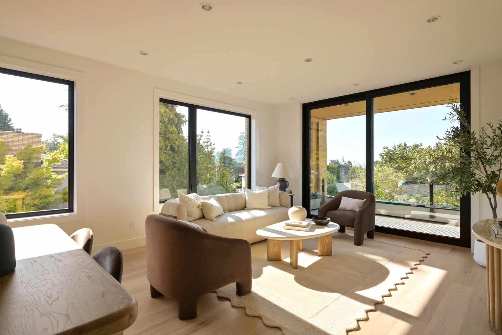 Bright living room with large windows and sliding glass doors in a modern home.