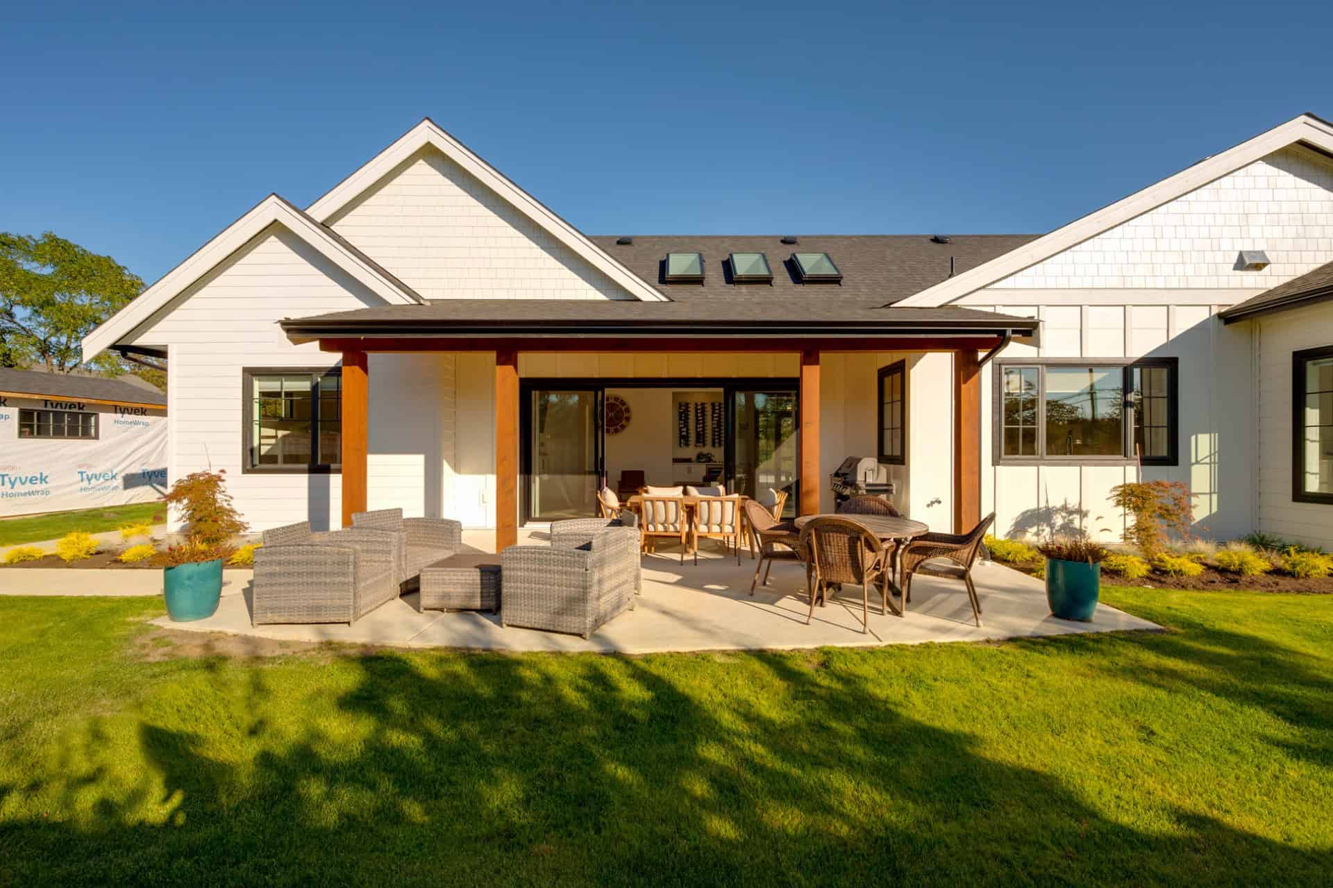 White Wolf Homes designed backyard with covered patio and seating in a modern Victoria BC home.