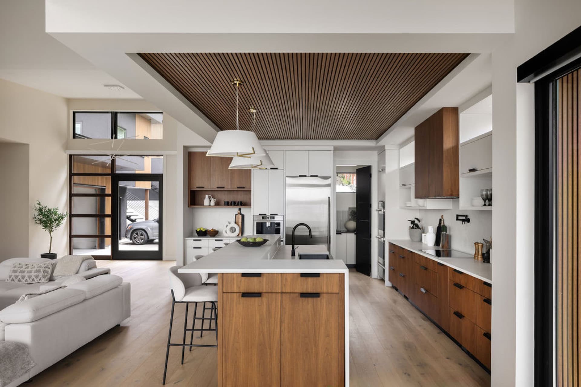 Open-concept kitchen with island, wooden cabinetry and modern appliances in Victoria home.