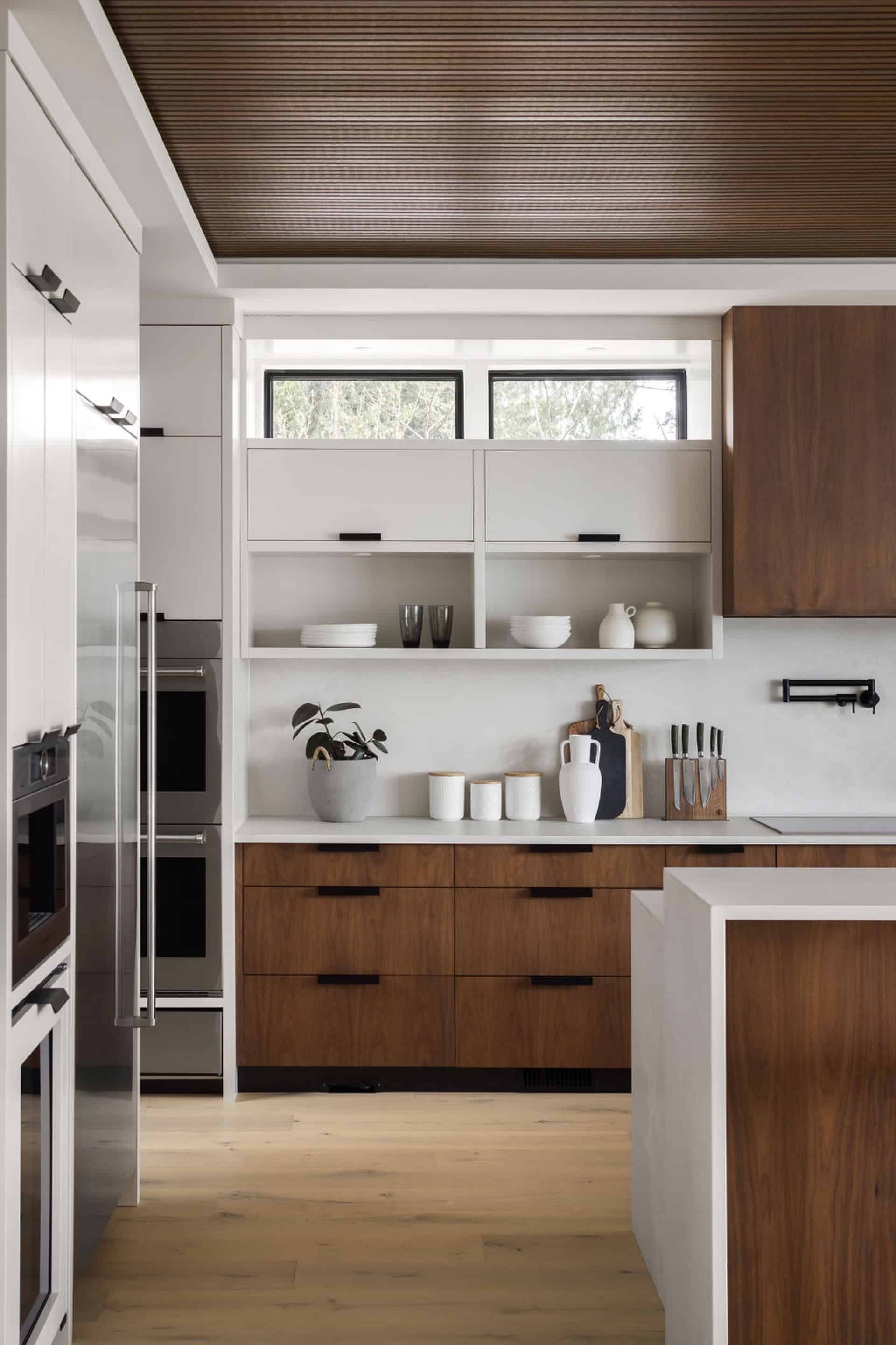 Modern kitchen in white and wood tones by White Wolf Homes in Victoria BC.