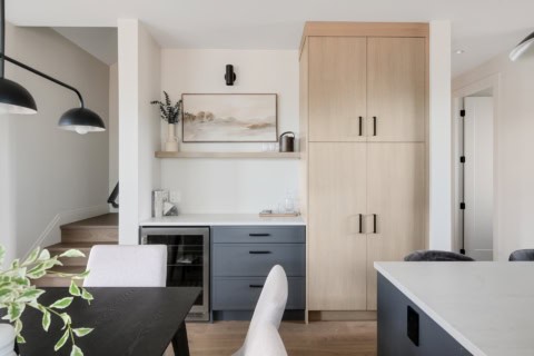 Interior view of Cedar & Stone home by White Wolf Homes with light cabinetry and island seating.