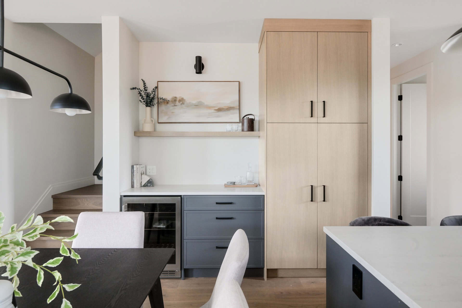 Interior view of Cedar & Stone home by White Wolf Homes with light cabinetry and island seating.