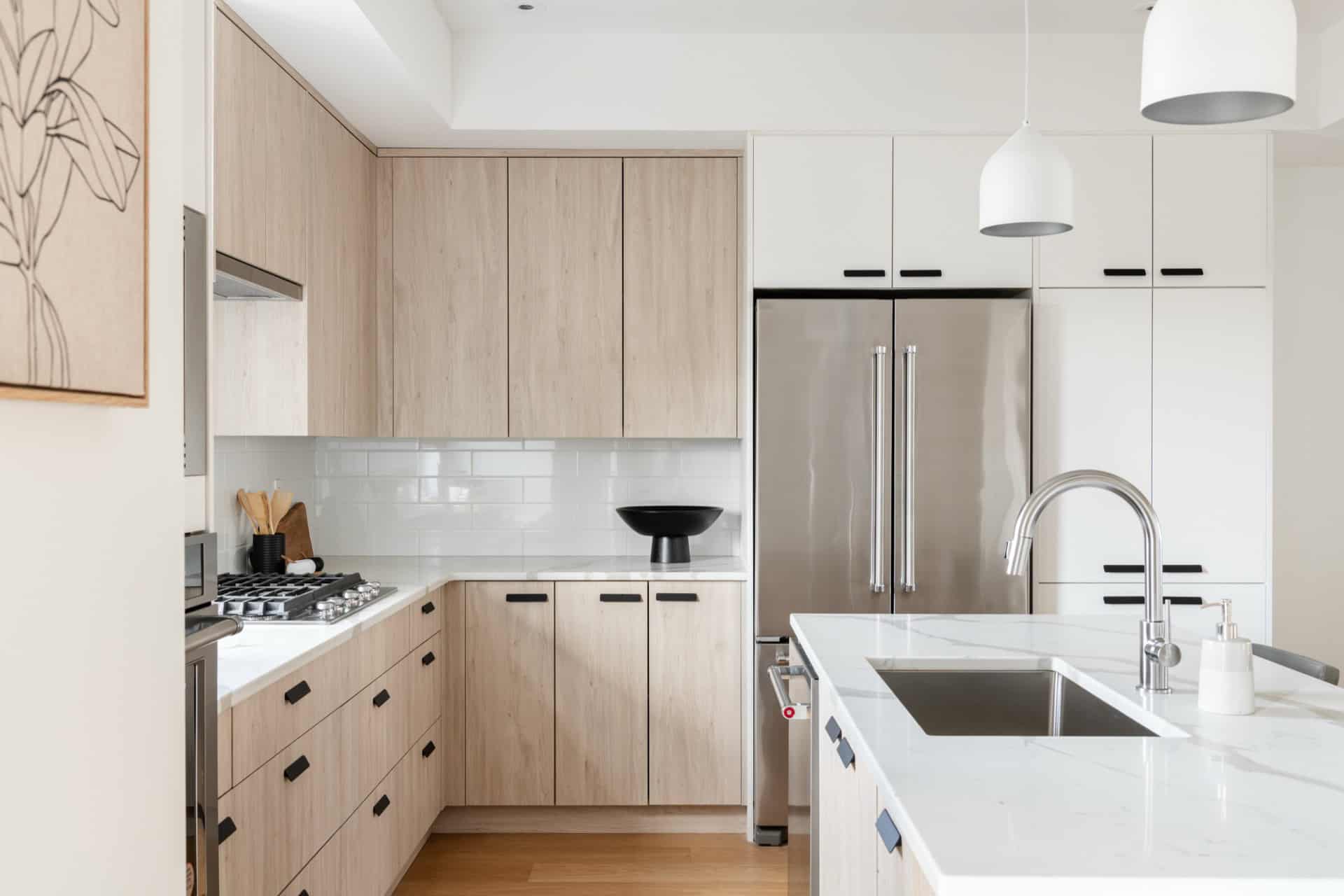 White Wolf Homes modern kitchen with light wood cabinets and stainless steel appliances in Victoria.