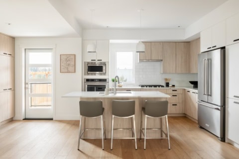 White Wolf Homes kitchen in Arbor Hill: modern bright space with island and light wood cabinets.