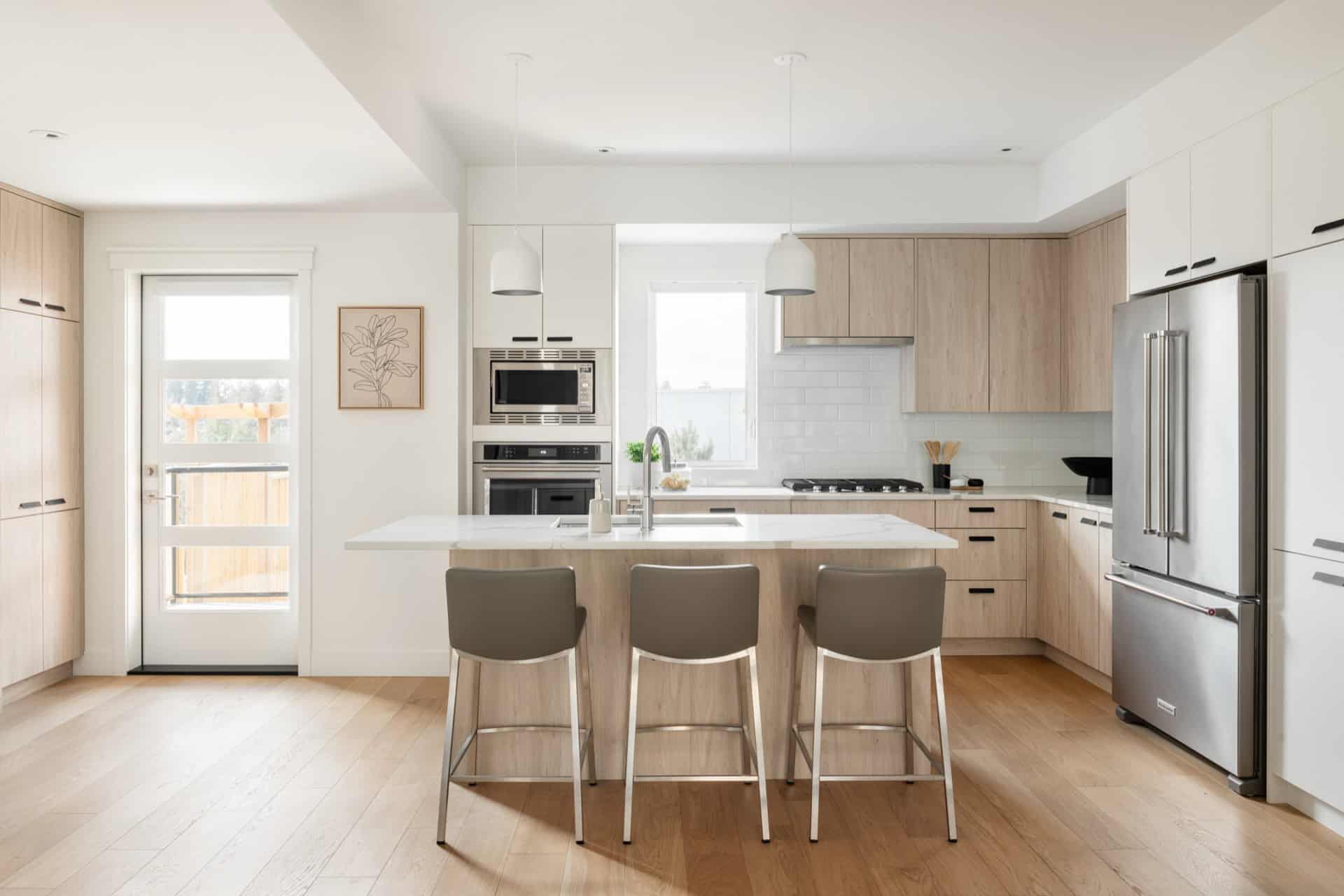 White Wolf Homes kitchen in Arbor Hill: modern bright space with island and light wood cabinets.
