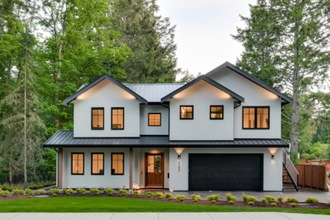Modern Victoria BC custom home by White Wolf Homes with a two-story façade and a dark garage door.