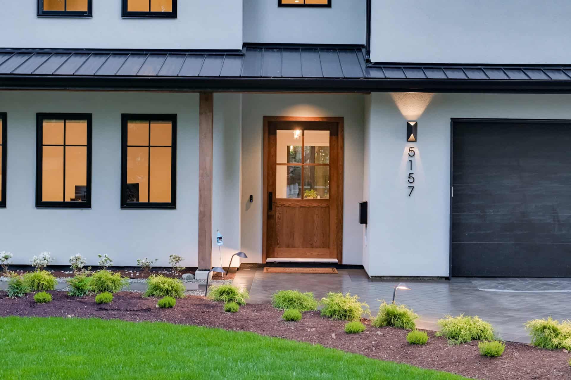 Custom home entrance by White Wolf Homes in Victoria BC, Stillwood, featuring a wooden door and modern windows.