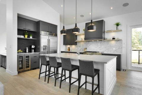 Modern kitchen with island, dark cabinets, and marble backsplash in Victoria BC home.