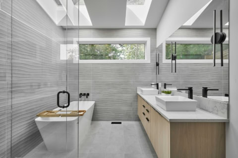 Contemporary bathroom with double vanity, freestanding tub, and glass shower enclosure.