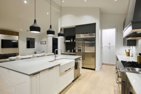 Modern open-concept kitchen with island and pendant lighting in a White Wolf Homes design.