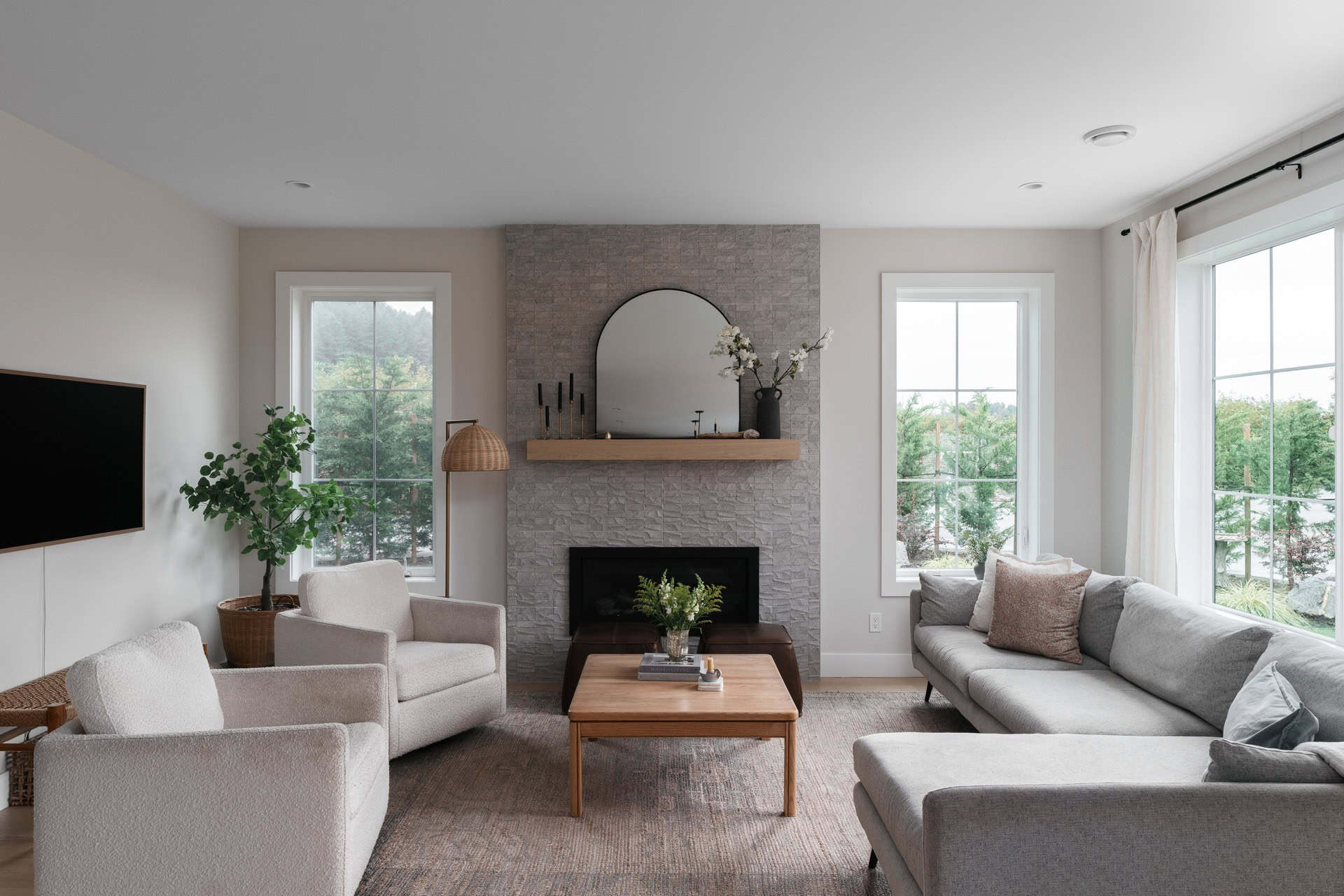 Bright living room with fireplace and large windows in a modern Victoria home.