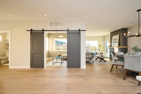 Open-concept living space with sliding barn doors and modern decor in Meadowview home by White Wolf Homes.