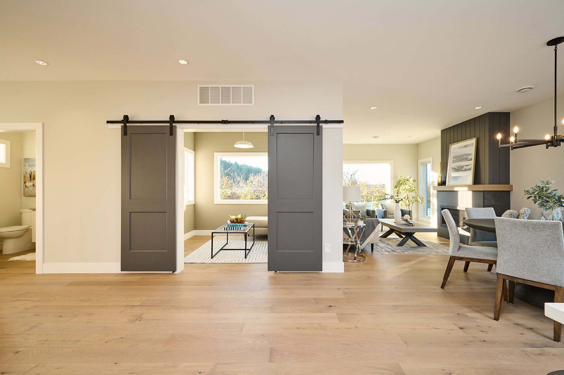 Open-concept living space with sliding barn doors and modern decor in Meadowview home by White Wolf Homes.