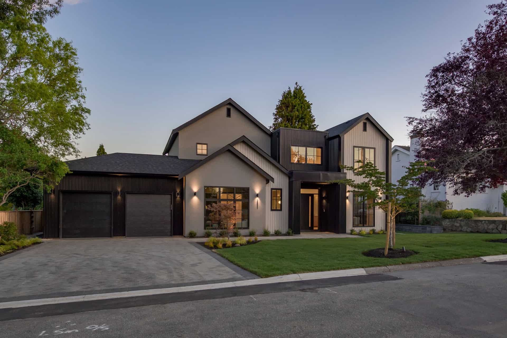 Modern two-story custom home in Victoria BC by White Wolf Homes with a three-car garage and manicured lawn.