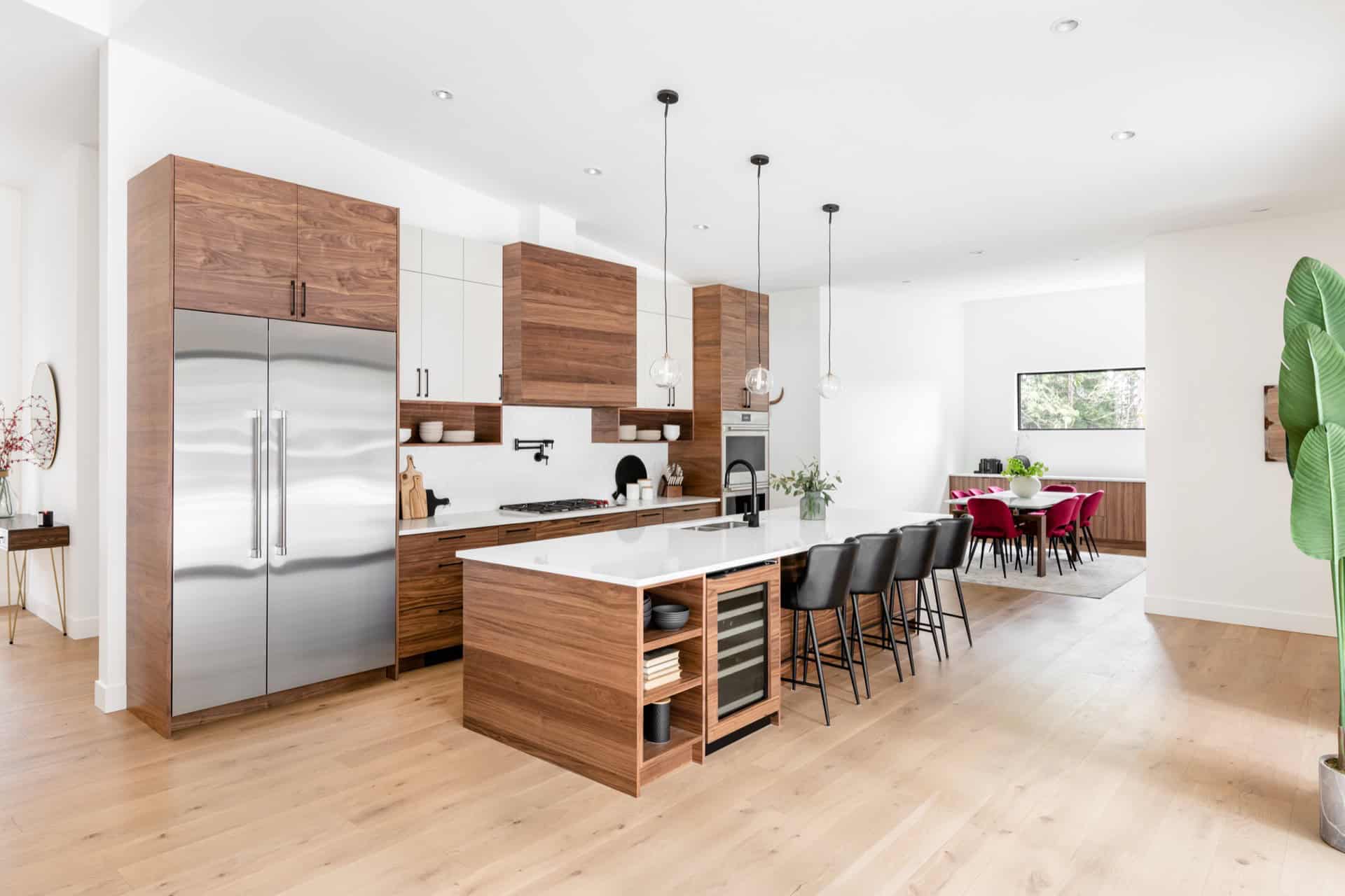 Open-concept kitchen with wooden cabinetry and island in Woodside project by White Wolf Homes.