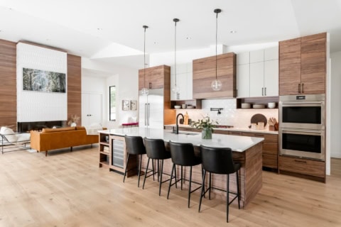 Modern open-concept kitchen with island, hardwood floors, and stainless steel appliances.