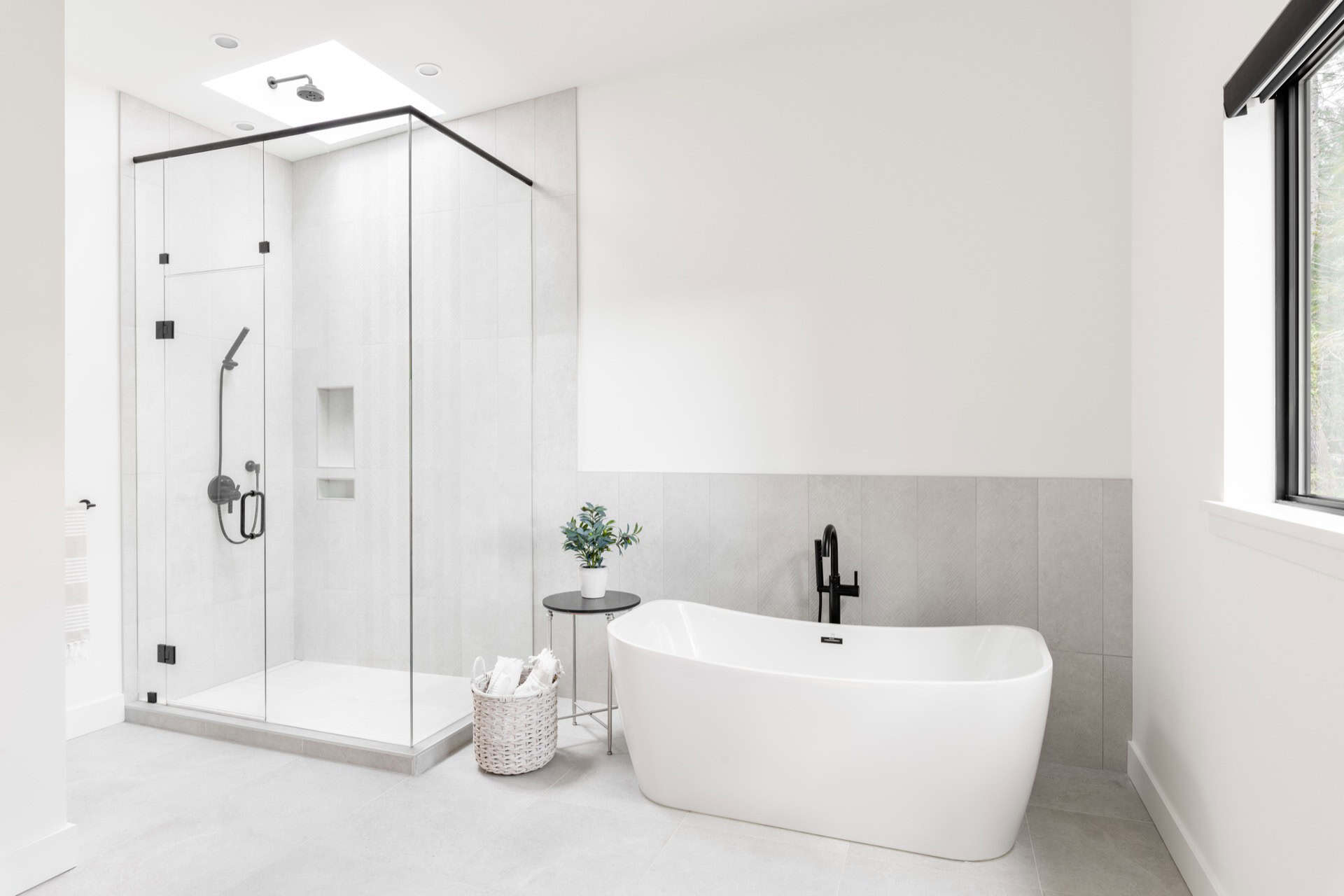 Modern white bathroom with freestanding tub and glass shower enclosure in Victoria BC.